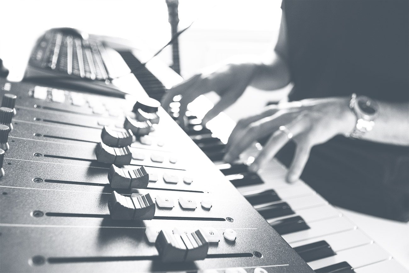 Mixing control and a keyboard being played by Alistair Brown writing music